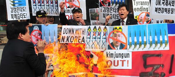 Activistas conservadores de Corea del Sur abrasan la bandera de Corea del Norte como una protesta contra los cohetazos - Sputnik Mundo