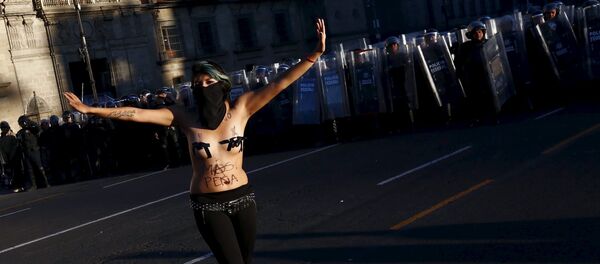 Una manifestante hace gestos frente a la policía antidisturbios durante los enfrentamientos con la policía antidisturbios en una marcha por el aniversario de la masacre de la plaza Tlatelolco en 1968 - Sputnik Mundo
