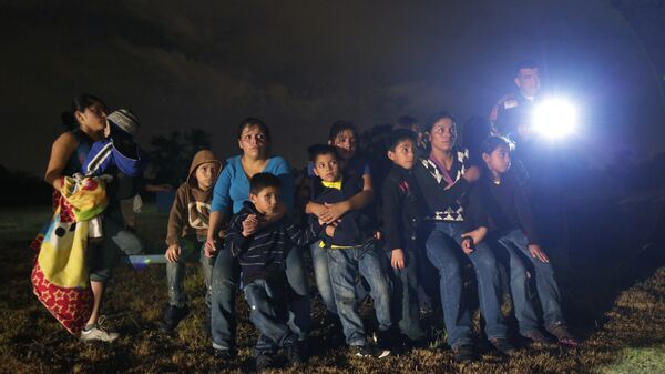 A group of young migrants from Honduras and El Salvador who crossed the U.S.-Mexico border illegally as they are stopped in Granjeno, Texas - Sputnik Mundo