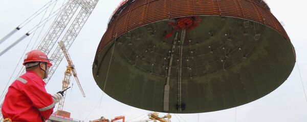 A worker looks on as the dome roof of a generator unit is lifted to be installed, at Tianwan Nuclear Power Plant, in Lianyungang, Jiangsu province, China, September 26, 2015. - Sputnik Mundo