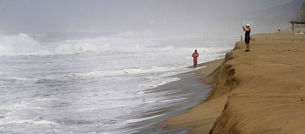 Un hombre toma fotografías de las olas en la playa de Acapulco, México (archivo) - Sputnik Mundo