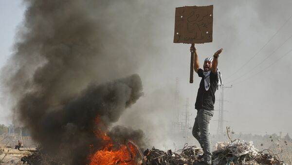 Palestinian protester shouts during clashes with Israeli troops near the border with Israel, in the east of Gaza City - Sputnik Mundo