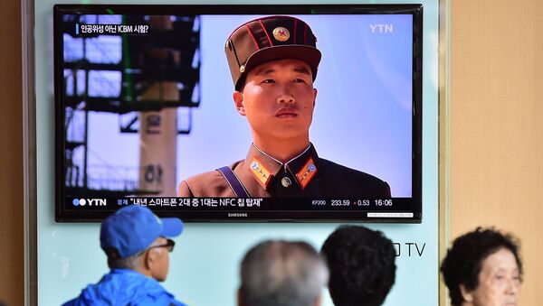 People watch a news report at a railway station in Seoul - Sputnik Mundo