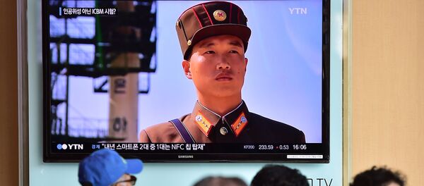 People watch a news report at a railway station in Seoul - Sputnik Mundo