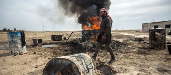 Un hombre trabaja en una refinería de petróleo improvisada en Raqqa - Sputnik Mundo