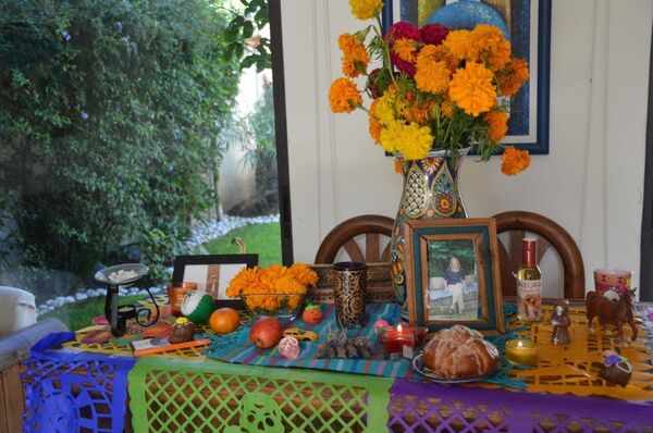 Las familias adornan sus casas con comidas, bebidas, objetos y, recientemente, fotografías de sus seres queridos - Sputnik Mundo