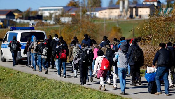 Policía local escolta a un grupo de refugiados despues de cruzar frontera austro-alemana - Sputnik Mundo