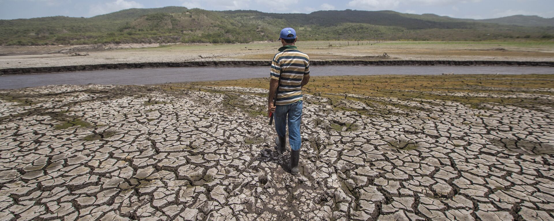 A man crosses the reservoir of Las Canoas, 60 km from Managua, on his way home - Sputnik Mundo, 1920, 09.11.2023