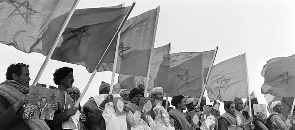 Marroquiés con los retratos del rey Hasan II, textos del Corán y banderas de Marruecos en la Marcha Verde - Sputnik Mundo