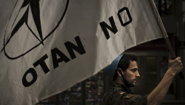 Member of Basque pacifist movement protest against the military attack on Libya by International coalition forces, as holds up a wave against NATO ''No OTAN'', in Bilbao, northern Spain - Sputnik Mundo