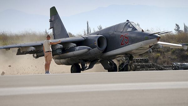 A Russian ground staff member signals to pilot of Sukhoi Su-25 fighter jet at Hmeymim air base near Latakia - Sputnik Mundo