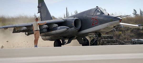 A Russian ground staff member signals to pilot of Sukhoi Su-25 fighter jet at Hmeymim air base near Latakia - Sputnik Mundo