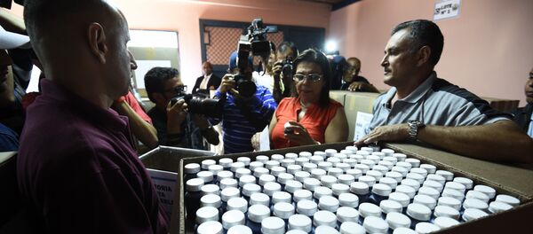 Empleados del CNE muestran la tinta indeleble que se utilizará para marcar los votantes en los colegios electorales - Sputnik Mundo