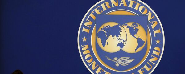 Visitors are silhouetted against the logo of the International Monetary Fund at the main venue for the IMF and World Bank annual meeting in Tokyo in this October 10, 2012 Visitors are silhouetted against the logo of the International Monetary Fund at the main venue for the IMF and World Bank annual meeting in Tokyo in this October 10, 2012 - Sputnik Mundo