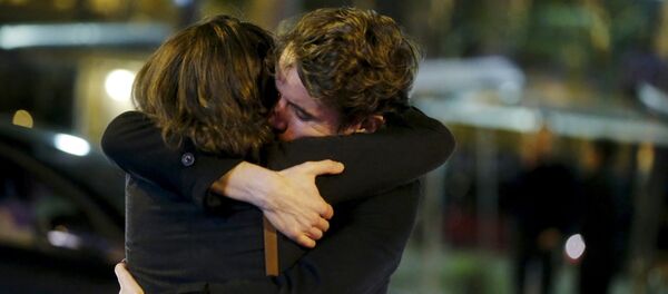 People hug on the street near the Bataclan concert hall following fatal attacks in Paris, France, November 14, 2015 - Sputnik Mundo