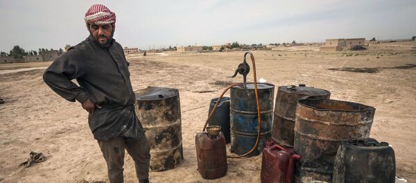 Un hombre trabaja en una refinería de petróleo improvisada en Raqqa, Siria - Sputnik Mundo