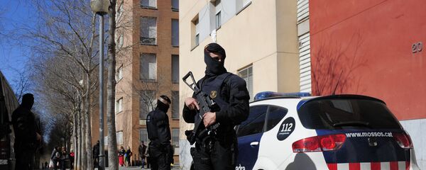 Mossos d'Esquadra regional police officers stand guard during a raid in one of the region's biggest operations against jihad activity in Sabadell, near Barcelona, Spain, Wednesday, April 8, 2015 - Sputnik Mundo