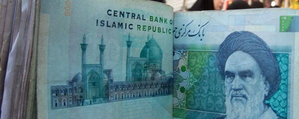 An Iraqi money dealer counts Iranian rial banknotes bearing a portrait of the late founder of the Islamic Republic of Iran, Ayatollah Ruhollah Khomeini, at an exchange office in Baghdad on February 3, 2012. - Sputnik Mundo