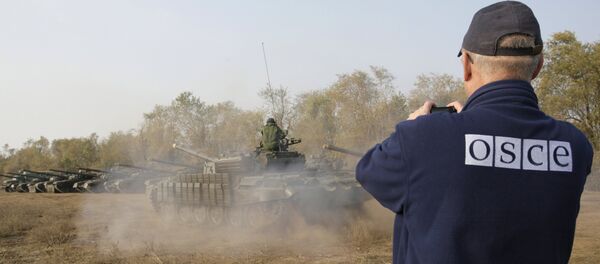 Un observador de la OSCE registra la retirada de tanques en la localidad de Stajanov, bajo control de las fuerzas de la RPL. 20 de octubre de 2015 - Sputnik Mundo
