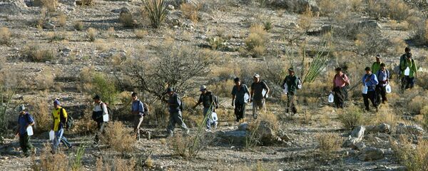 Mexican immigrants walk in line through the Arizona desert near Sasabe, Sonora state, in an attempt to illegally cross the Mexican-US border - Sputnik Mundo