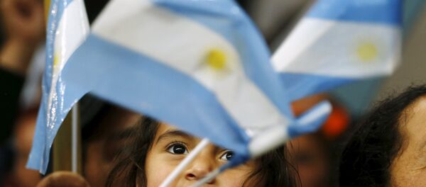 A child waves Argentine national flags during the final campaign rally of Argentina's ruling party candidate Daniel Scioli in La Matanza, on the outskirts of Buenos Aires, November 19, 2015. - Sputnik Mundo