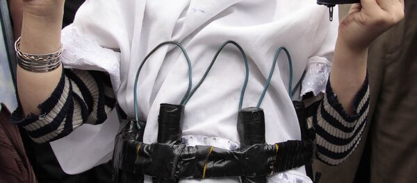 Una niña con Corán y un cinturón de explosivos falso (archivo) - Sputnik Mundo