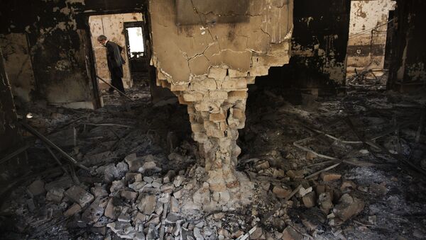 A man wearing a surgical mask walks, 14 October 2015, amongst the debris of the damaged and burnt-out MSF Trauma Centre in Kunduz, northern Afghanistan - Sputnik Mundo