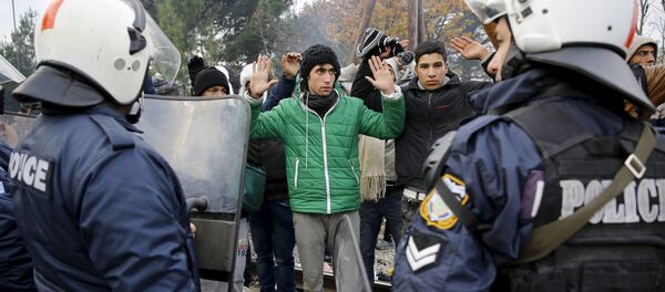 Refugiados de Marruecos enfrente del cordón de policía griega en la fronera con Macedonia - Sputnik Mundo