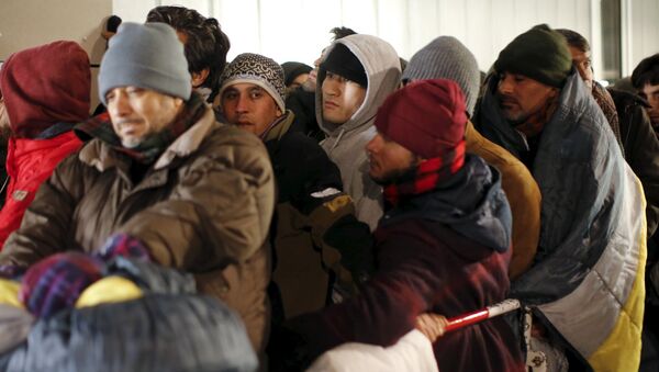 Migrants queue on a street to enter the compound outside the Berlin Office of Health and Social Affairs for their registration process in Berlin - Sputnik Mundo