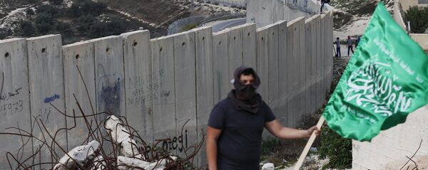 Un palestino con la bandera del grupo islamista Hamás - Sputnik Mundo
