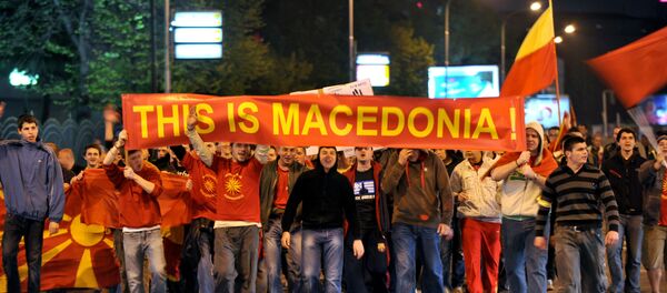Grupo de jóvenes con carteles y banderas de Macedonia durante una protesta en Skopie - Sputnik Mundo