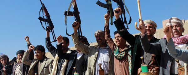 Supporters of Shiite Huthi rebels and militiamen shout slogans raising their weapons during a rally against the Saudi-led coalition - Sputnik Mundo