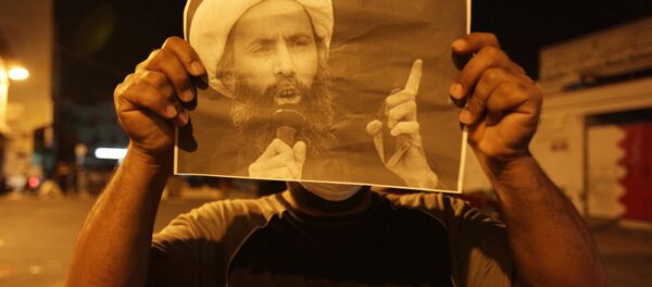 Un manifestante lleva la imagen del clérigo chií Nimr Baqir al Nimr - Sputnik Mundo