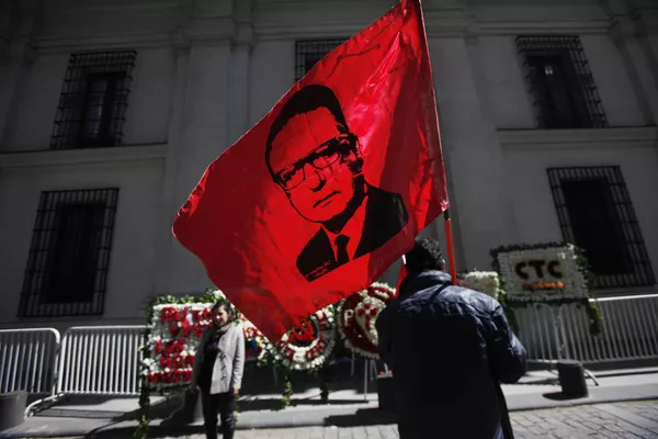 Un hombre alza la bandera con la cara de Salvador Allende frente al Palacio de La Moneda en Chile Un hombre alza la bandera con la cara de Salvador Allende frente al Palacio de La Moneda en Chile - Sputnik Mundo