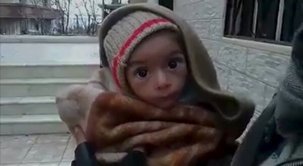A toddler is held up to the camera in this still image taken from video said to be shot in Madaya on January 5, 2016 - Sputnik Mundo