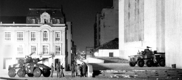 Colombian army officers standing near armored cars talk about their next move after a half dozen of the armored cars hammered the Palace of Justice for an hour Thursday morning with cannon and machine gun fire in Bogota, Colombia, Nov. 7, 1985. - Sputnik Mundo