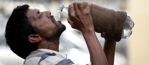 Un hombre bebe agua - Sputnik Mundo