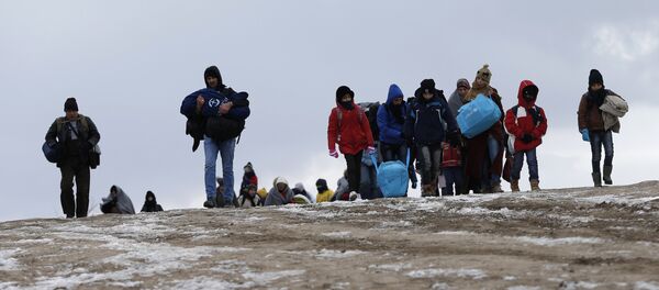Los migrantes cruzan un campo helado cerca de la frontera de Macedonia - Sputnik Mundo