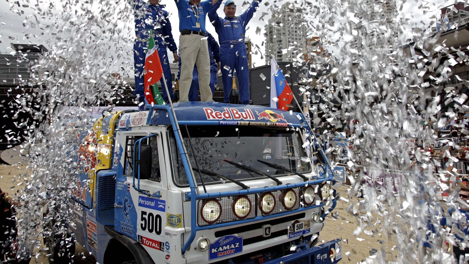Under a rain of confetti, Kamaz driver Vladimir Chagin, from Russia, right, celebrates with teammates on the top of his truck during the 2011 Argentina-Chile Dakar Rally podium ceremony in Buenos Aires, Argentina, Sunday, Jan. 16, 2011 Under a rain of confetti, Kamaz driver Vladimir Chagin, from Russia, right, celebrates with teammates on the top of his truck during the 2011 Argentina-Chile Dakar Rally podium ceremony in Buenos Aires, Argentina, Sunday, Jan. 16, 2011 - Sputnik Mundo, 1920, 28.09.2022