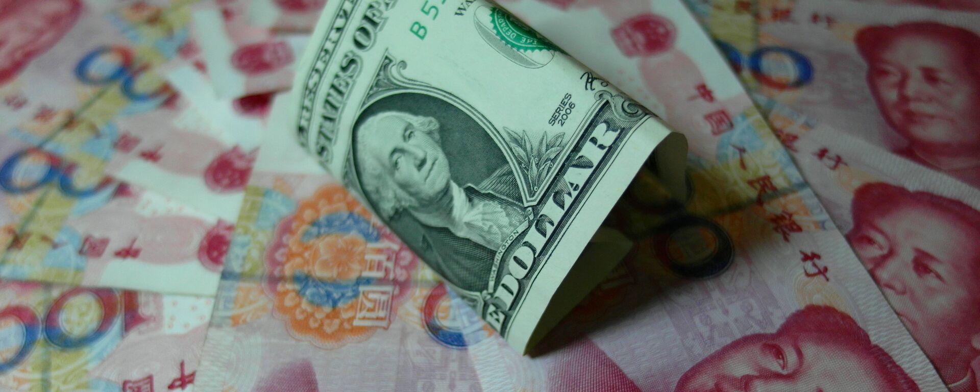 Yuan banknotes and US dollars are seen on a table in Yichang, central China's Hubei province on August 14, 2015 - Sputnik Mundo, 1920, 08.05.2024