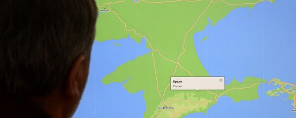 Un hombre mira en el mapa de la península de Crimea - Sputnik Mundo