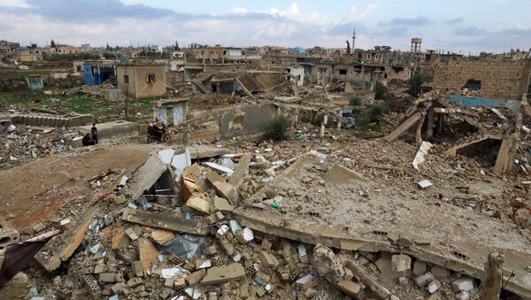 Civilians ride on a motorcycle past damaged buildings in the rebel held historic southern town of Bosra al-Sham - Sputnik Mundo