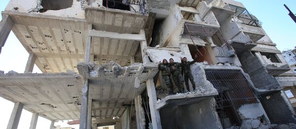 Members of the Syrian pro-government forces pose for a picture in a destroyed building in the strategic town of Salma, in the coastal Latakia province, on January 15, 2016, following its recapture from rebel fighters - Sputnik Mundo