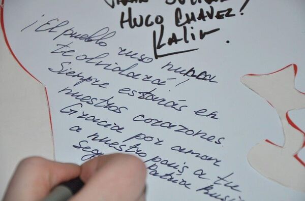 En el evento homenaje a Hugo Chávez los asistentes escribieron sus mensajes en un pendón, como una muestra del gran cariño y amor que sintió el pueblo ruso por el líder de la Revolución Bolivariana. Embajada de Venezuela en Moscú, 02.03.2016 - Sputnik Mundo