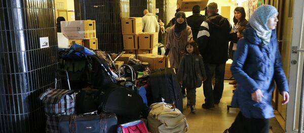 Migrants carry their goods upon their arrival at a refugee shelter in Friedenau city hall in Berlin's Tempelhof-Schoeneberg district, Germany - Sputnik Mundo