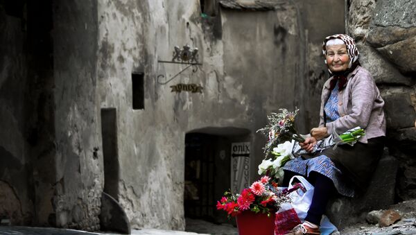 Una mujer vende flores - Sputnik Mundo