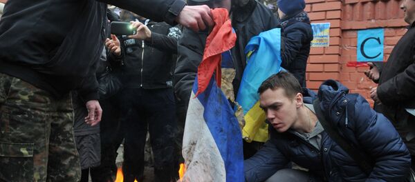 Los manifestantes prenden fuego al tricolor ruso en Ucrania Los manifestantes prenden fuego al tricolor ruso en Ucrania - Sputnik Mundo