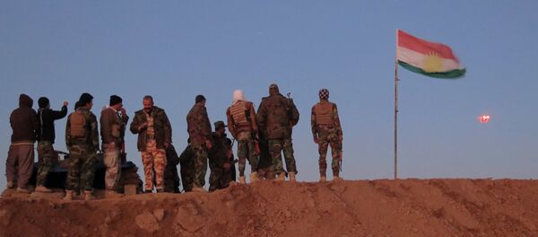 Militantes de Peshmerga cerca de la bandera de Kurdistán iraquí - Sputnik Mundo