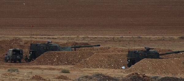 Turkish soldiers hold their positions with their artillery pieces, bottom, on a hilltop in the outskirts of Suruc, at the Turkey-Syria border, overlooking Kobani, Syria, background, during fighting between Syrian Kurds and the militants of Islamic State group, Thursday, Oct. 16, 2014 - Sputnik Mundo