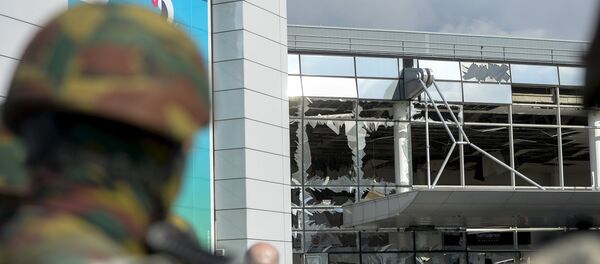 Windows of the terminal at Brussels national airport are seen broken during a ceremony following bomb attacks in Brussels metro and Belgium's National airport of Zaventem - Sputnik Mundo
